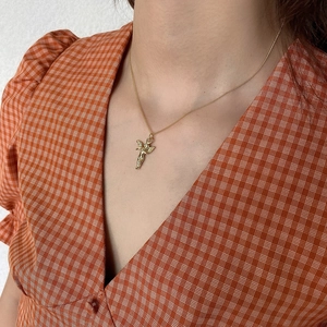 Close-up of a 925 sterling silver gold angel pendant necklace worn by a model