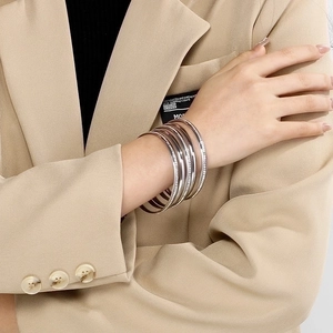 Close-up of layered 5.5mm silver and rose gold bangles with cubic zirconia on wrist