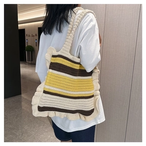 Handmade striped crochet tote bag with ruffles and long strap shown on model's shoulder