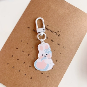 Detailed macro shot of a cute acrylic rabbit keychain with pink and blue accents