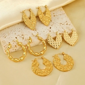 Detail of 18K gold-plated geometric earrings with hammered texture and twisted designs