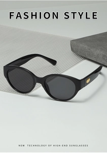 Détail de lunettes de soleil œil-de-chat noires avec accents métalliques ovales dorés
