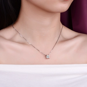 Close-up of a s925 silver moissanite pendant necklace worn on a female model