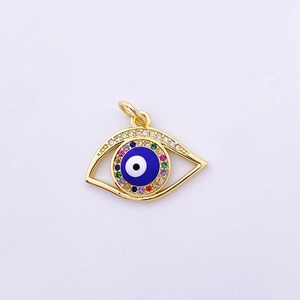 Macro detail of gold evil eye pendant with blue enamel and colorful zircon stones