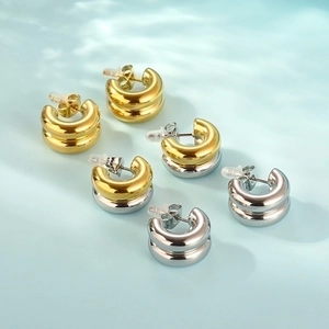 Detailed view of two-tone C-shape hoop earrings in gold, silver, and mixed finishes