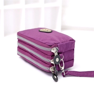 Close-up of a purple nylon three-zipper pouch showing layered texture and wrist strap