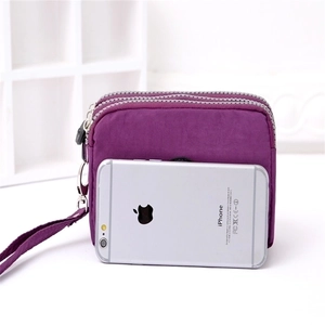 Close-up of a purple three-zipper nylon mini pouch with a matching wrist strap detail