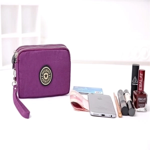 Purple washed nylon pouch with three zippers showing mobile phone and card storage