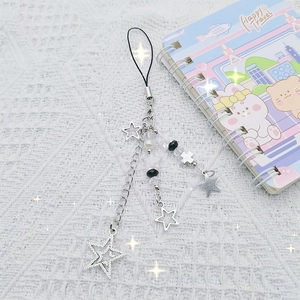 Y2K silver metal phone charm with star and cross pendants on textured white background