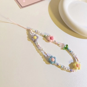 Detailed shot of pink tulip beaded phone charm with colorful beads on a white surface