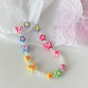 Detail of colorful beaded phone strap with pink tulips, butterflies and faux pearls