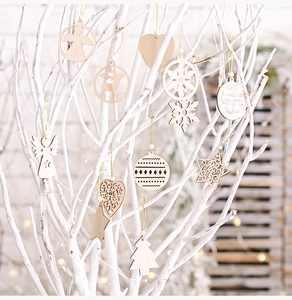 Detail showing wooden Christmas ornaments with laser-cut patterns and festive text on a branch