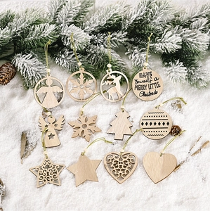 Detail of 11 laser-cut wooden Christmas ornaments on snow with pine needles