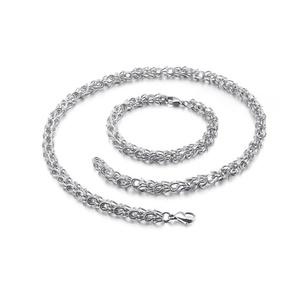 Minimalist silver stainless steel crown necklace and woven chain set on white background