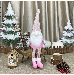 Detail of pink Christmas gnome with long legs and knitted hat on a festive wooden stand