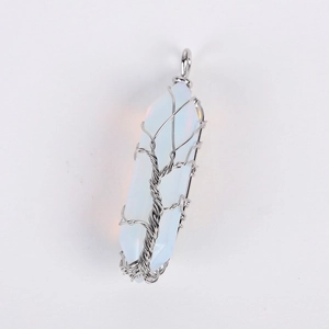 Macro detail of silver wire wrapped tree of life pendant with white hexagonal opal crystal