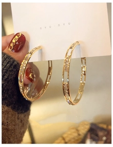 Detail showing the double-track gold hoop earrings with sparkling crystal accents