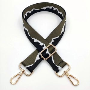 Detailed view of jacquard pattern strap with gold metal buckles and mountain design