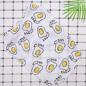 Close-up of white mesh pet vest with yellow fried egg print on blue checkered background