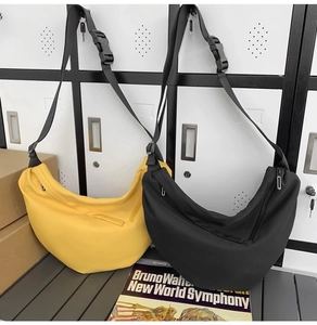 Detail view of yellow and black crescent crossbody bags with adjustable straps and buckles