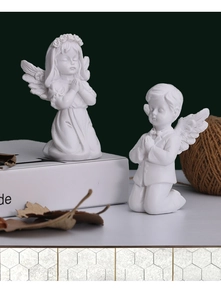 Detailweergave van biddende engelenbeeldjes van witte hars met een matte afwerking