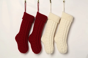 Detail of red and cream knitted Christmas stockings showing thick cable knit texture