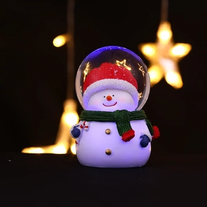 Gros plan d'une boule de neige lumineuse avec chapeau rouge et éclat bleu