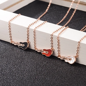 Elegant rose gold guitar necklace featuring white shell inlay and creative musical design