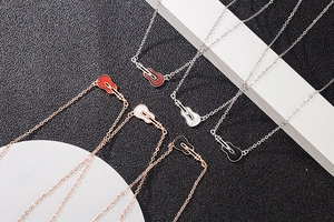 Detailed macro view of colorful guitar pendants on s925 silver and rose gold chains