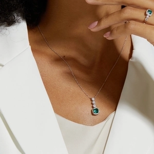 Elegant S925 silver necklace and ring set with emerald-cut green gemstone on a model