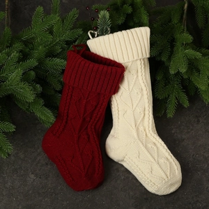 Knitted Christmas stockings in burgundy and cream white with berries and pine decor