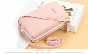 Detail of pink litchi grain PU leather phone bag with retro metal clasp and long strap