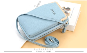 Detail of light blue crossbody phone bag with lychee texture and gold metal clasp