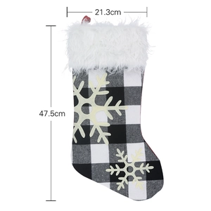Christmas stocking with black and white plaid design, snowflake pattern and white fur cuff