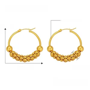 Macro detail of gold titanium steel C-hoop earrings featuring wavy bead chain texture