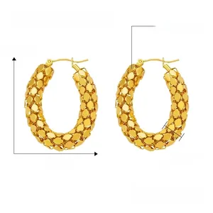 Detailed view of gold titanium steel U-shaped earrings with textured honeycomb pattern