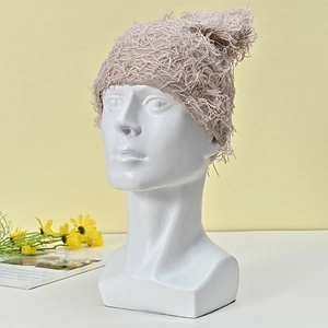 Minimalist beige textured knit beanie hat displayed on a model for winter warmth
