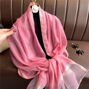 Elegante bufanda de seda rosa con borde dorado mostrada en un maniquí