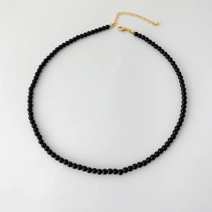 Detailed top view of black onyx beaded necklace with gold lobster clasp and extender