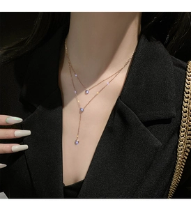 Collana a doppio strato in titanio oro rosa con tre gemme trasparenti su modella