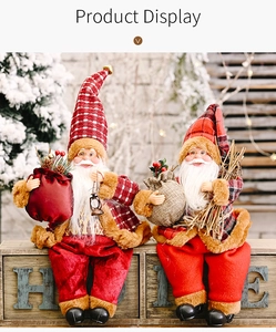 Detail of two standing Santa dolls with plaid hats and festive velvet clothing decorations