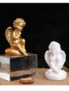 Détail de figurines d'anges en résine dorée et blanche aux finitions romantiques fines