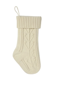Close-up of cream cable knit Christmas stocking with decorative leaf patterns and hanging loop