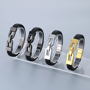 Detail view of woven leather bracelets with vintage silver, black, and gold metal clasps