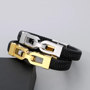 Close-up of gold and silver U-link clasps on black braided leather bracelets for men