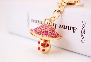 Close-up of pink and red rhinestone mushroom keychain with golden lobster clasp and ring