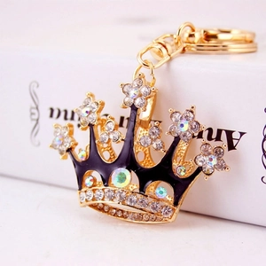 Golden crown keychain with black enamel and crystals on a clean white background