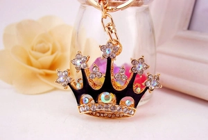 Detailed close-up of a sparkling crown keychain with crystals and black enamel finish