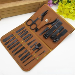 Macro detail of 18-piece black matte manicure set in a brown faux leather zipper case