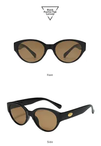 Détail de lunettes de soleil ovales, monture noire et verres marrons avec accents dorés